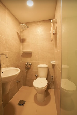 A small, compact bathroom with a sink, toilet, and shower.