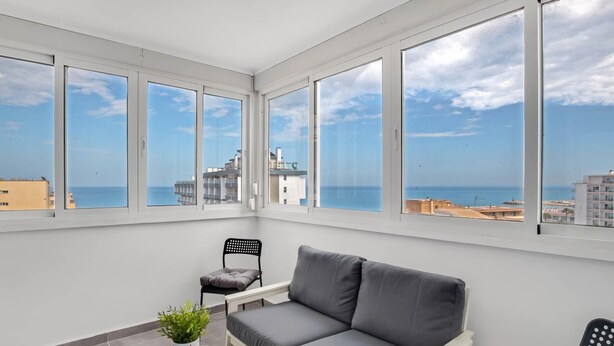 A balcony with a grey sofa, a small round table with a plant, and two chairs. - Micarlo 701 - Second line of beach. 2 bedrooms (Torremolinos)