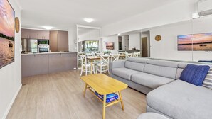 A modern living space with a kitchen, dining area, and a sofa. - Spinnaker Apt 6- Mooloolaba Beach  (Mooloolaba)