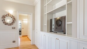 A hallway with white cabinetry, a flat-screen TV, and a decorative wreath on the wall. - Monteverde 2BDR  Penthouse (Roma)