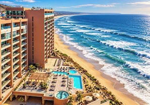 A beachfront hotel with multiple balconies, a pool area, and a view of the ocean. - Luxurious Ocean View Apartment  (Tijuana)