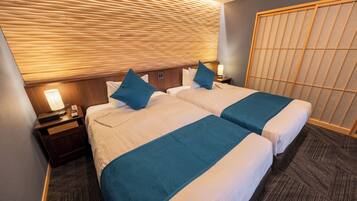 A hotel room with two beds, a wooden headboard, a nightstand with a lamp, and a large window with blinds.