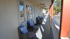 A covered outdoor seating area with wicker furniture and striped cushions.