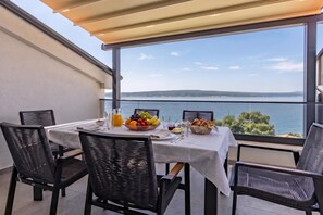 A dining area with a table set for two, overlooking a body of water.