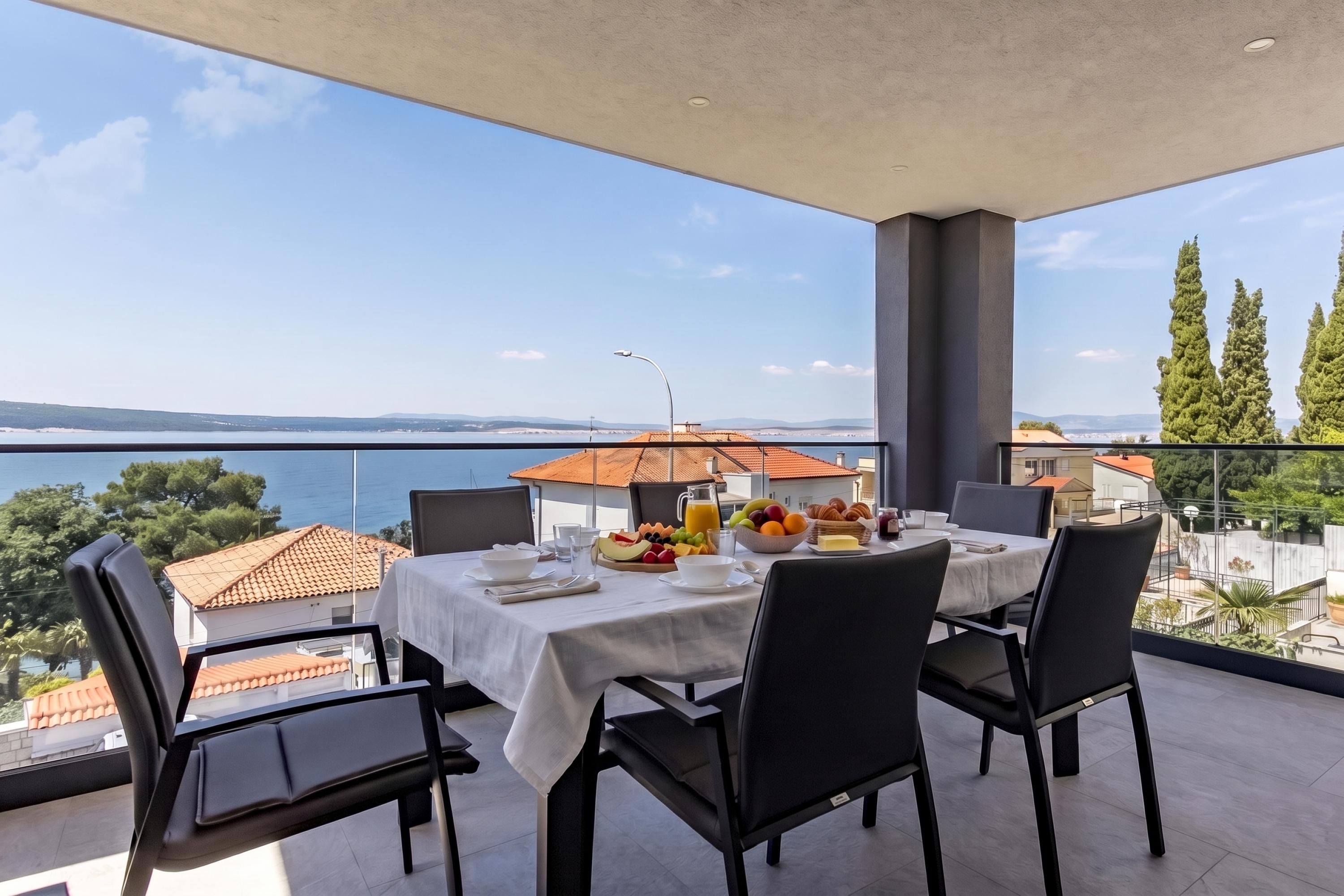 A balcony with a table set for breakfast overlooking a body of water.