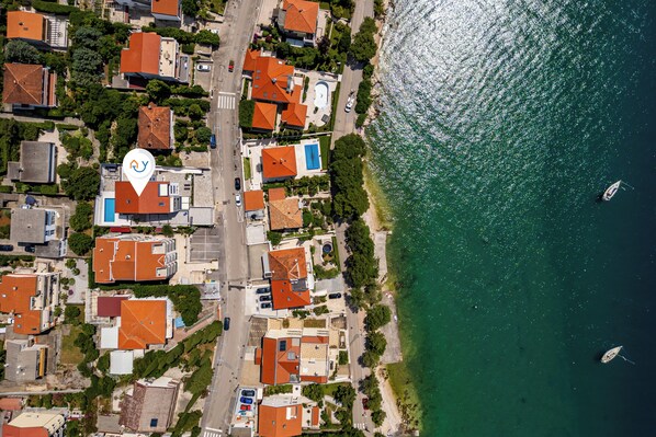 An aerial view of a coastal residential area with houses, a road, and a body of water. - Pool Apartment Sunset With Sea View, Crikvenica, Croatia (Crikvenica)