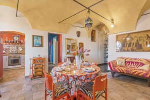 A dining area with a round table, chairs, and a chandelier.