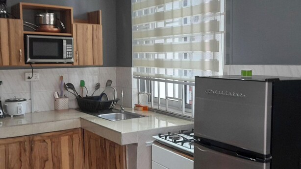Una cocina moderna con microondas, estufa y pileta incorporados.