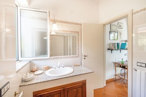 A bathroom with a sink, mirror, and tiled walls.