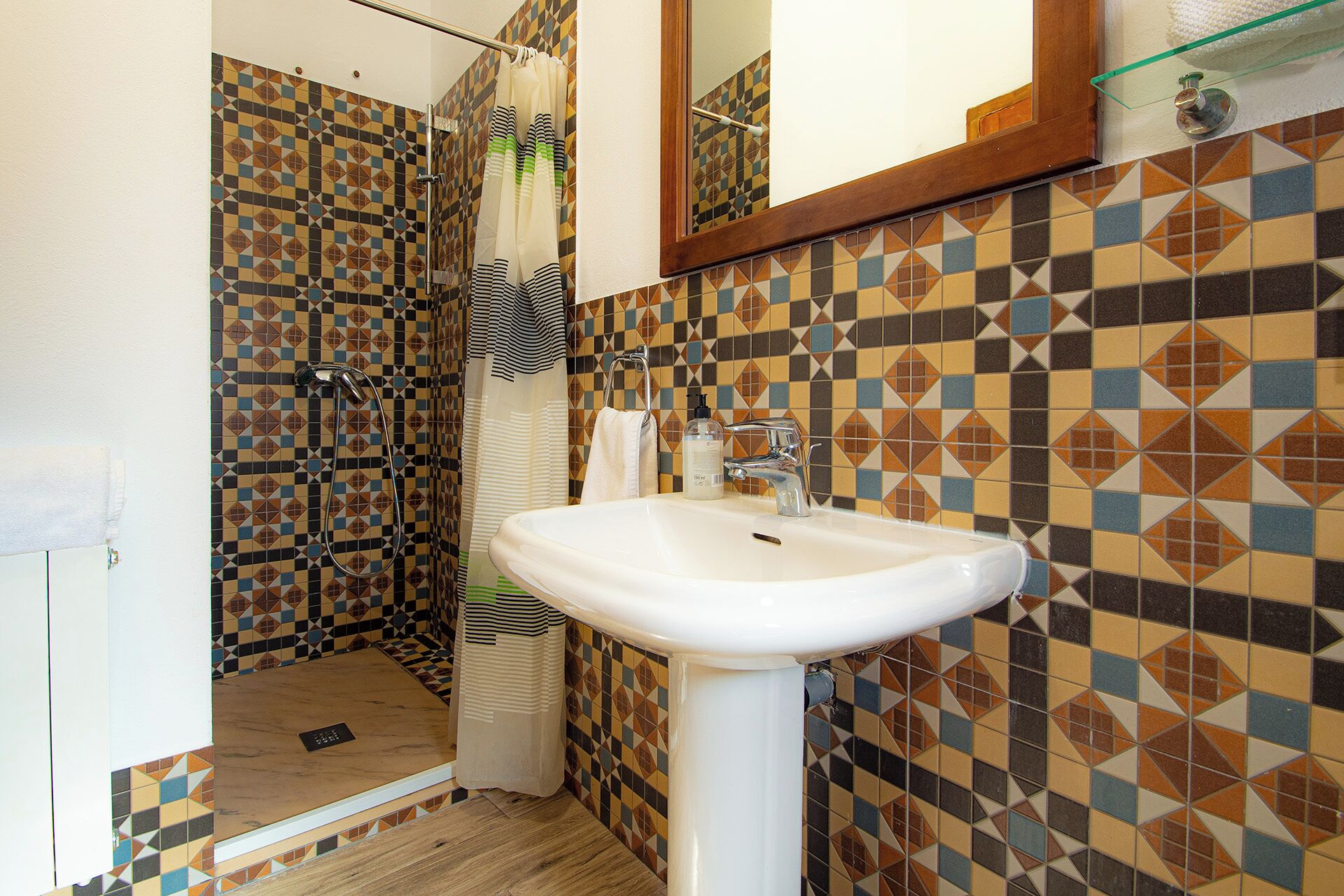 Une salle de bain avec une douche, un lavabo et un miroir.