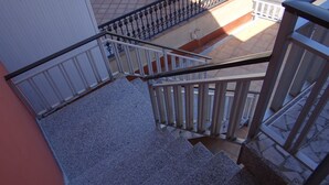 Una escalera con barandales de metal y peldaños de granito que conduce a un piso superior.