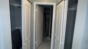 A hallway with a tiled floor, white walls, and a ceiling light. - Cozy 3-bedroom house in peaceful Spring Hill with WiFi, AC. Sleeps up to 15 (Spring Hill)