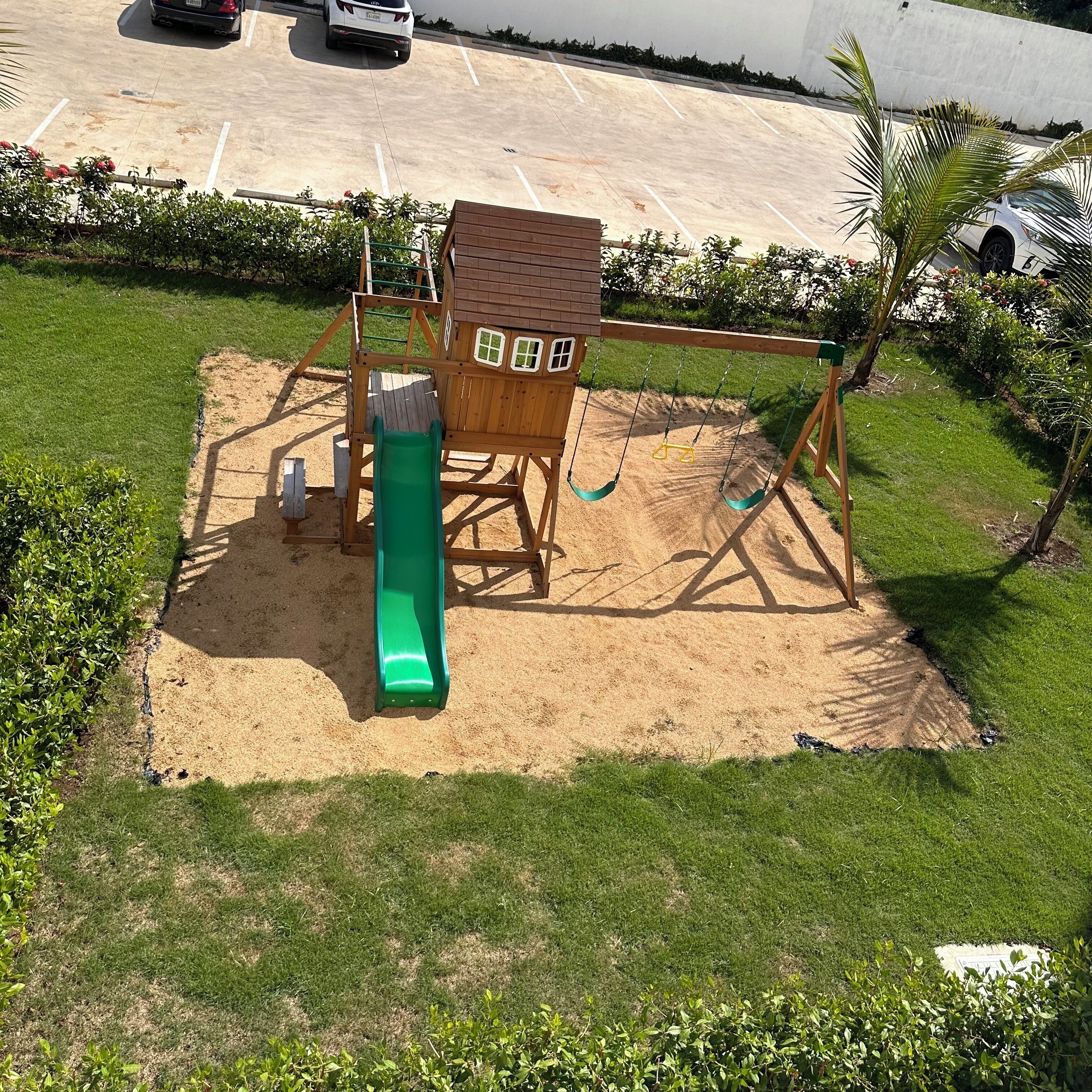 A playground with a slide, swings, and a climbing structure.
