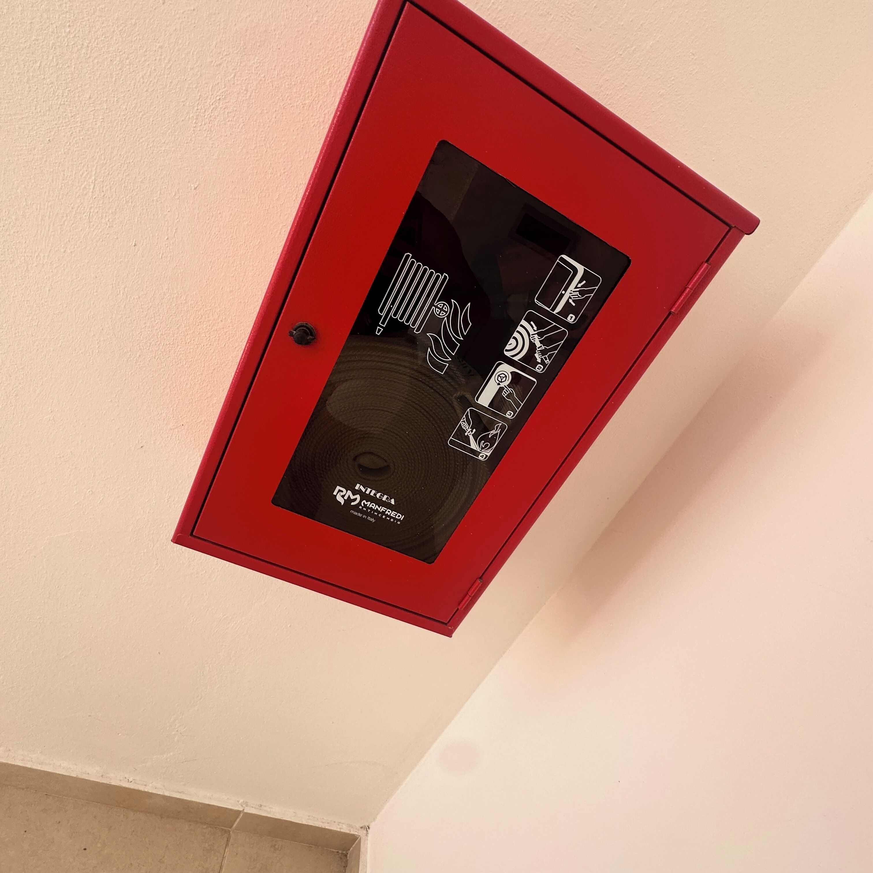 A red electrical box with a black panel and warning labels.