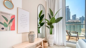 Una sala de estar moderna con vistas a la ciudad, un espejo grande y arte decorativo en la pared.