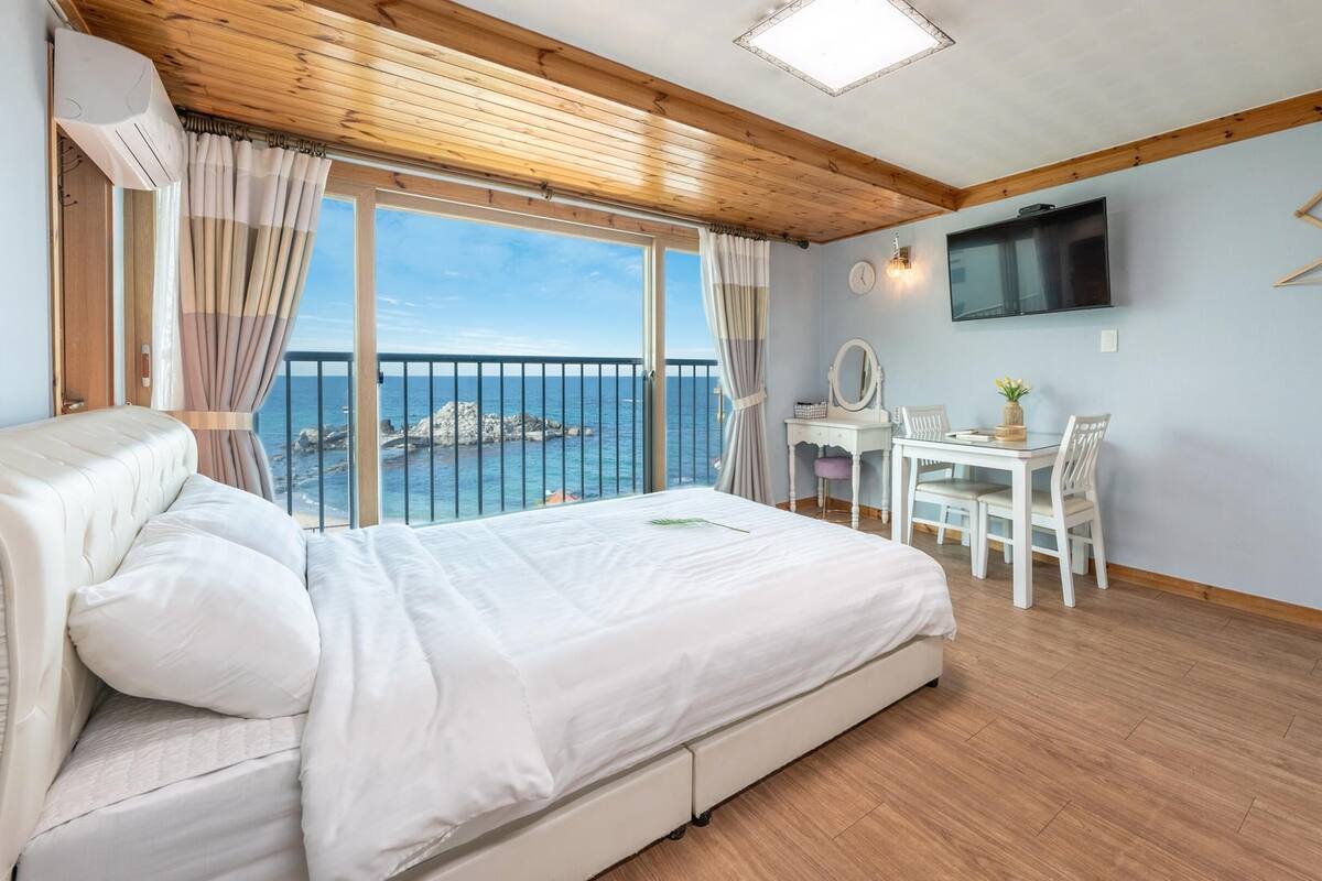 Une chambre à coucher avec un lit, un bureau et un téléviseur.