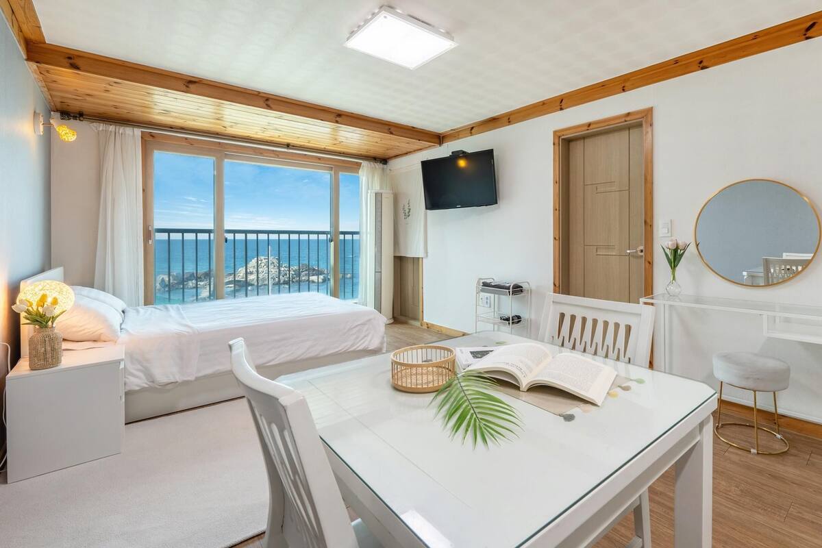 Une chambre à coucher avec un lit, une table de chevet et un téléviseur.