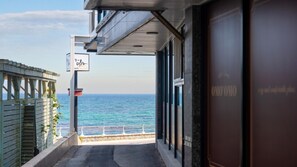 A view from a balcony overlooking the sea, with a sign for 'Inspiration' visible.