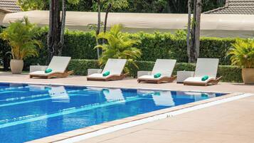 Ein Pool mit Liegestühlen und Topfpflanzen.