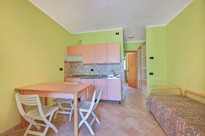 A compact kitchen with a dining area, a small table, and two chairs.