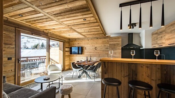 Een modern interieur met houten plafond, een bar, een eetgedeelte en grote ramen.