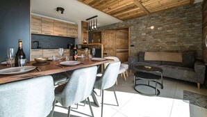 Een moderne keuken met houten kasten, een eettafel gedekt voor vier personen en een stenen muur.