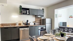 A modern kitchen with grey cabinets, a built-in microwave, and a dishwasher. - Cap Océan by Interhome (Capbreton)