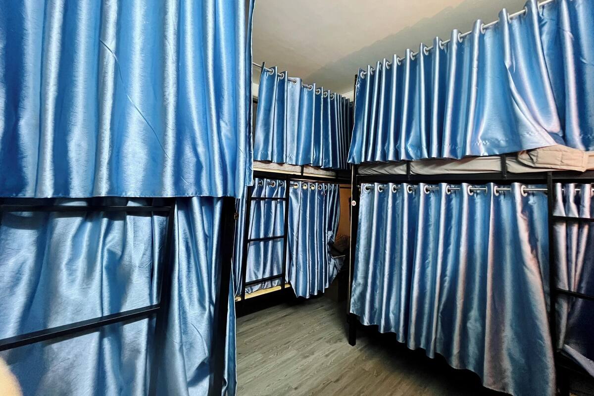 A room with bunk beds and blue curtains.
