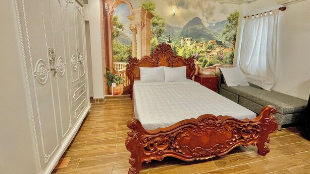 A bedroom with a large bed, a wardrobe, and a mural of a mountainous landscape. - AULE HOSTEL (Ho Chi Minh City)