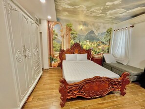 A bedroom with a large bed, a wardrobe, and a mural of a mountainous landscape. - AULE HOSTEL (Ho Chi Minh City)