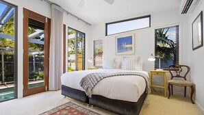 Un dormitorio con una cama grande, un escritorio, una silla y una ventana con persianas.