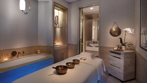 A modern spa room with a large bathtub, a massage table, and a small sink. - Luxurious studio in St Regis Palm View (Dubai)