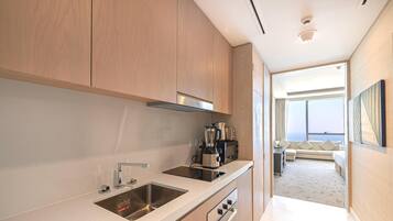 A modern kitchen with stainless steel appliances, a built-in oven, and a large window overlooking a balcony.