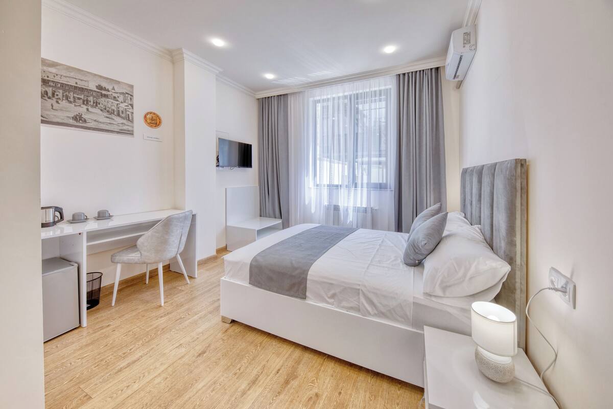 Una habitación de hotel moderna con una cama, un escritorio y una silla.