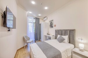 Een moderne hotelkamer met een groot bed, een bureau, een stoel en een televisie.
