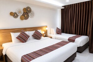Habitación de hotel con dos camas, cabecera, una obra de arte en la pared y una cortina.