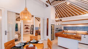 Una cocina moderna con una isla de madera, armarios blancos y un ventanal grande.