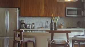 Una cocina moderna con armarios de madera, electrodomésticos de acero inoxidable e iluminación colgante.