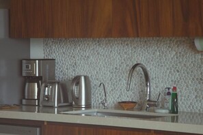 A kitchen with a coffee maker, toaster, kettle, and a sink with a faucet. - Walk to Beach - Luxury 2 bed 2 bath at Armadillo (Zihuatanejo)