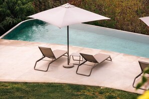 A poolside area with two lounge chairs and a large umbrella. - Walk to Beach - Luxury 2 bed 2 bath at Armadillo (Zihuatanejo)