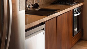 Una cocina con electrodomésticos de acero inoxidable, lavavajillas y armarios de madera.