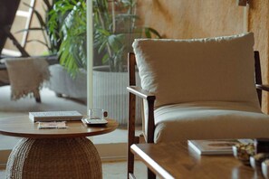 A cozy seating area with a cushioned chair, a round table, and a book.