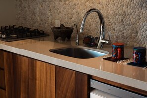 A kitchen with a double sink, a gas stove, and wooden cabinets.