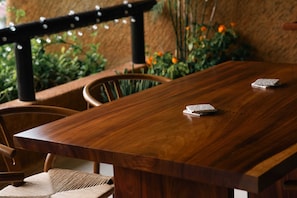 Enjoy a casual meal at this inviting dining table, surrounded by comfortable chairs and lush greenery.
