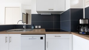 Una cocina moderna con un lavamanos, una cafetera y un lavavajillas.