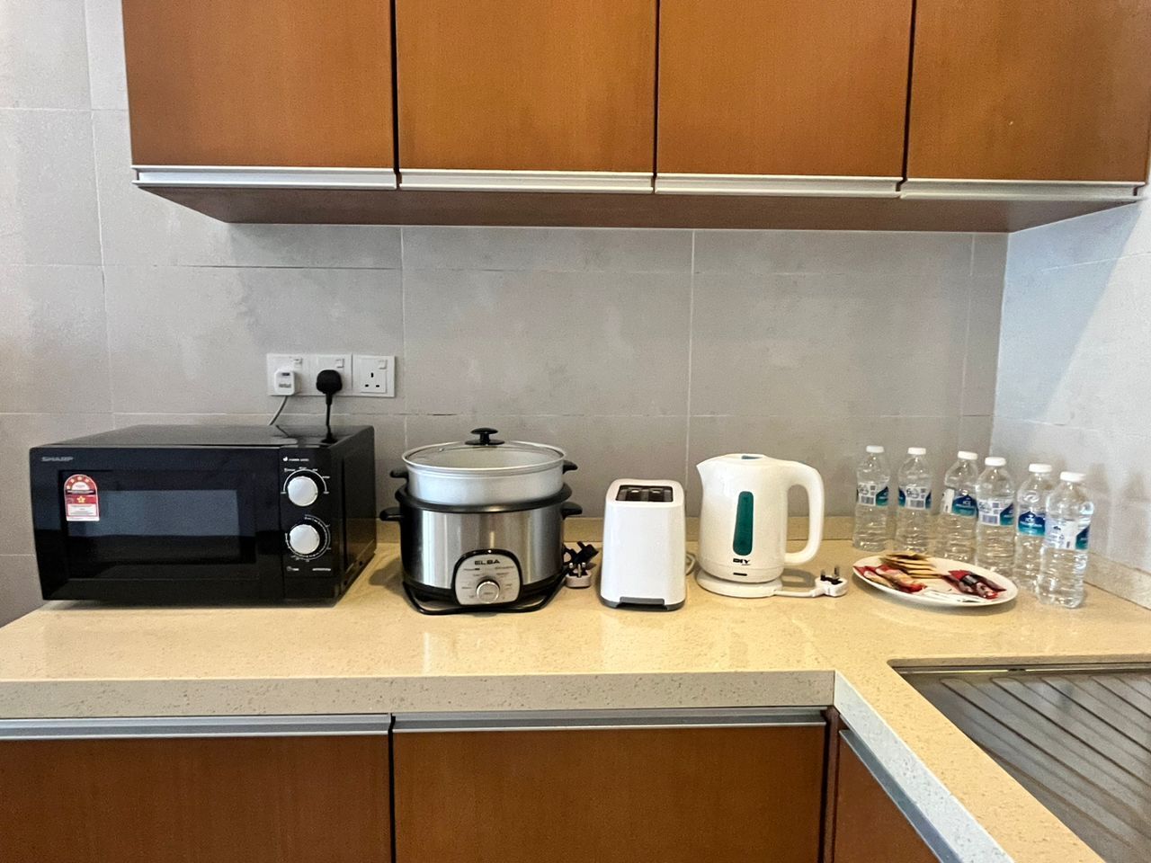 Cocina equipada con microondas, olla de cocción lenta, tostadora, hervidor y agua embotellada.