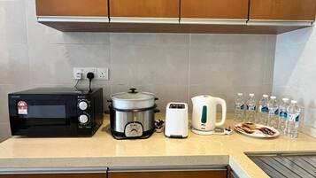Cocina equipada con microondas, olla de cocción lenta, tostadora, hervidor y agua embotellada.