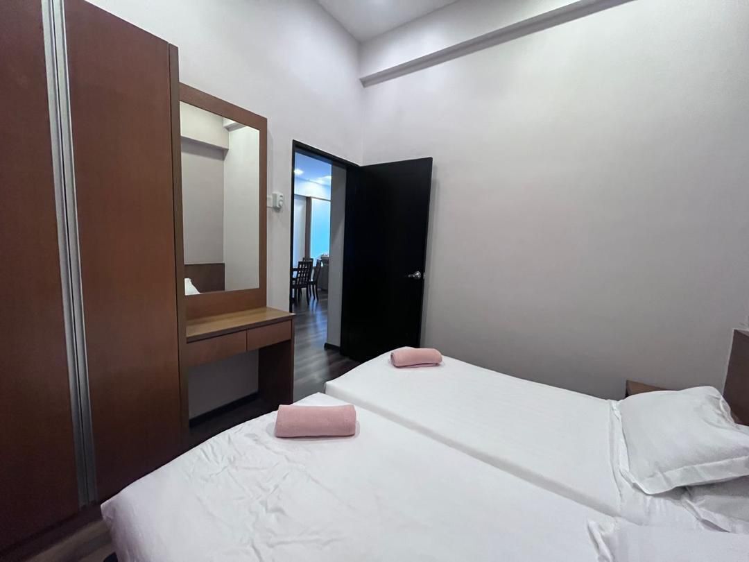 A hotel room with two beds, a wooden wardrobe, a mirror, and a view of the outside.