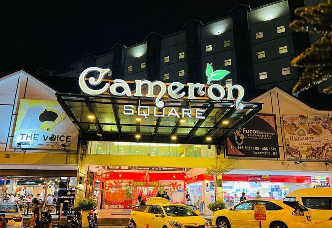 A hotel entrance with a prominent sign reading "Cameron Square".