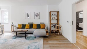 Un salon moderne avec un canapé, une table basse et une bibliothèque.